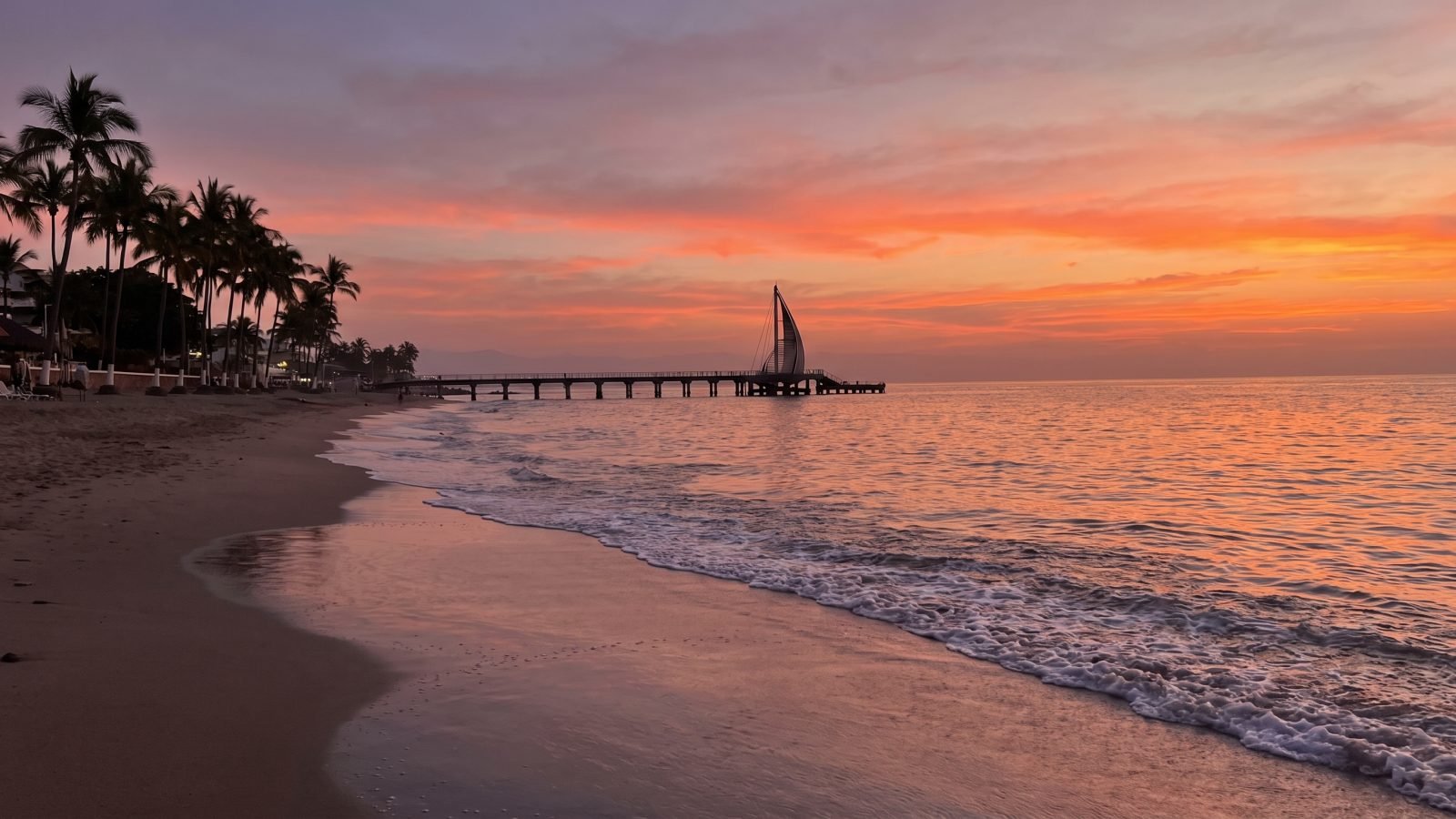 Sunset over Banderas Bay seen from Puerto Vallarta under a clear sky